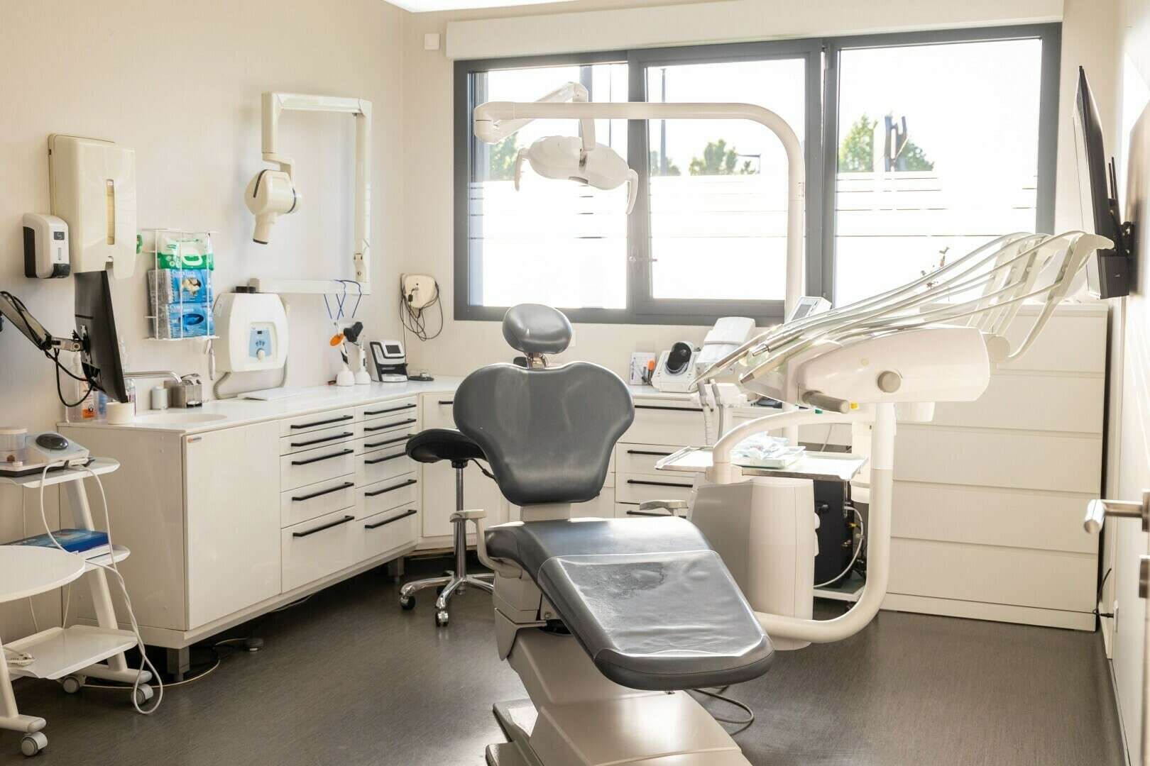 Salle de soins du Cabinet Dentaire de l'Olympe : le fauteuil, le scialytique et la lumière du jour